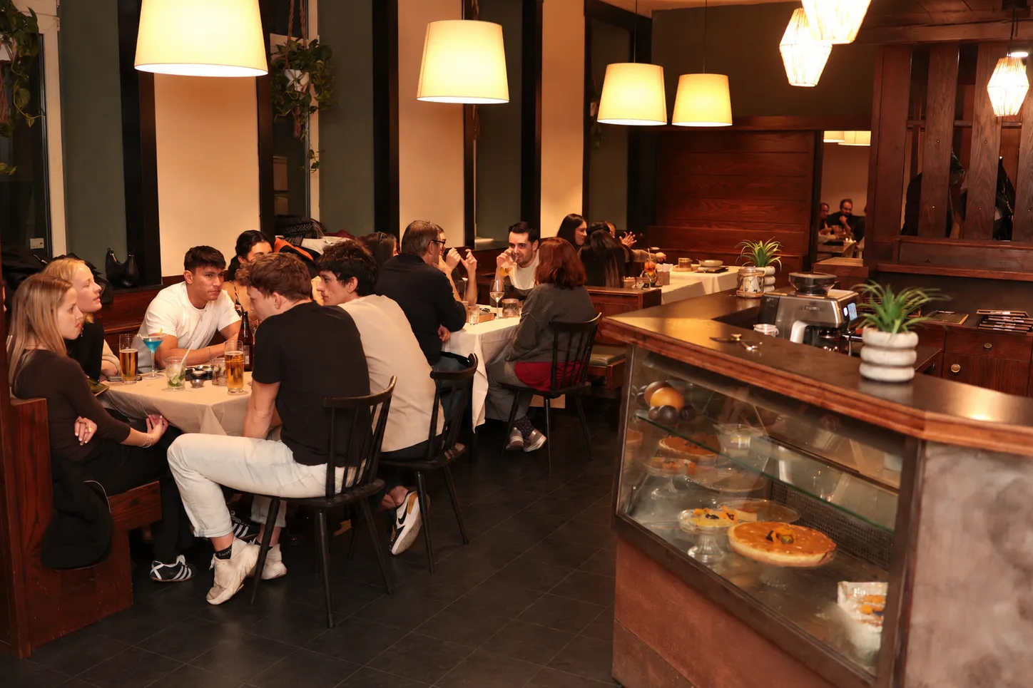 Gäste im Gastraum von Aguacate in Wien, die an Tischen sitzen und venezolanische Gerichte genießen.
