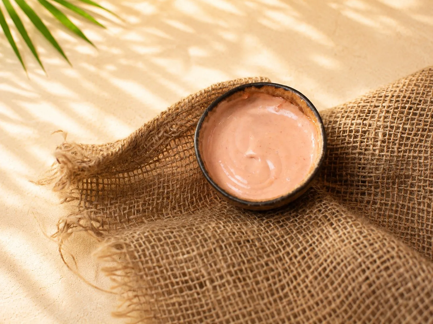 Cremige rosa Sauce (Pink Sauce) in einer kleinen Holzschale auf Jute.